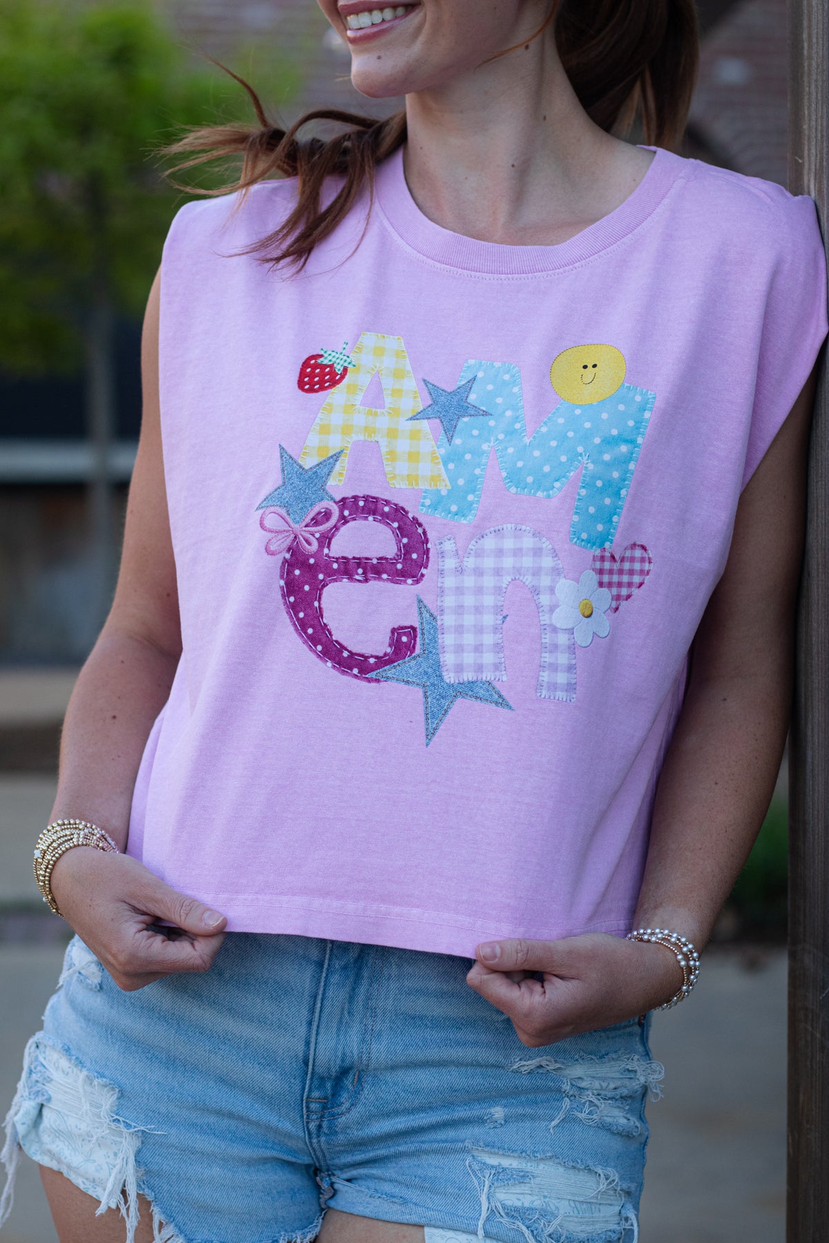 Close-up of a lavender Christian tank top featuring a colorful patchwork-style “Amen” graphic with stars, flowers, and playful patterns.